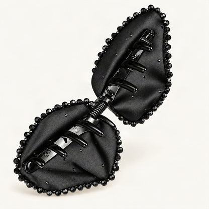 Black Satin Bow Claw Clip — open underside and spring mechanism on a warm ivory background [FITINY Hair]